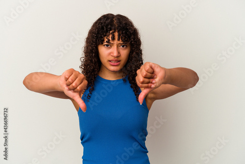 Young mixed race woman isolated on white background showing thumb down and expressing dislike.