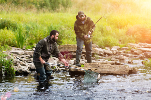 young men fishing on a mountain river © Roman