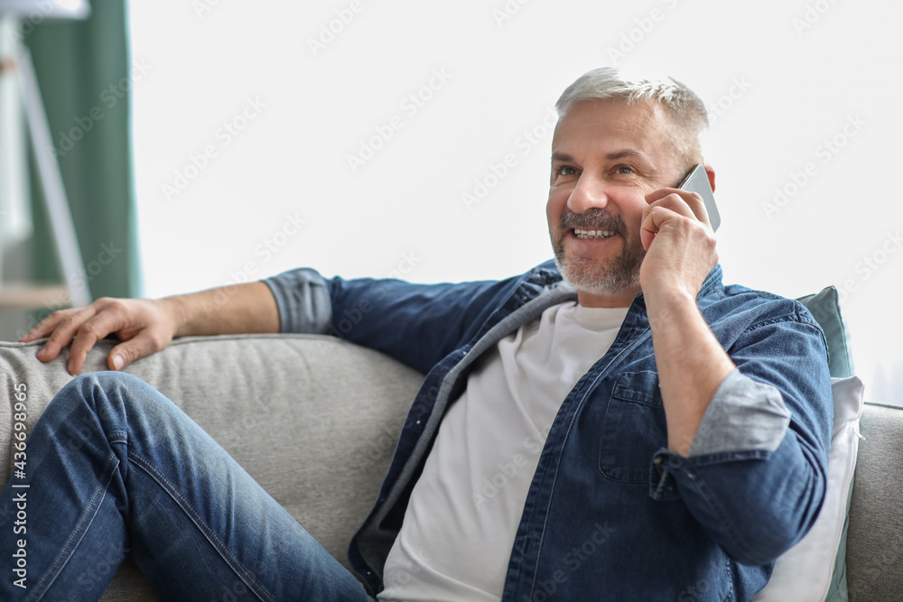 Side view of smiling senior man having phone conversation Side view of smiling senior man having phone conversation
