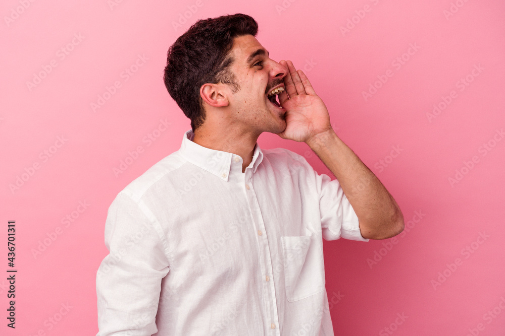 Young caucasian man isolated on pink background shouting and holding palm near opened mouth. Young caucasian man isolated on pink background shouting and holding palm near opened mouth.