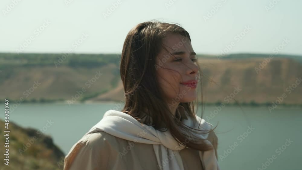 Beautiful brunette in casual wear enjoying amazing view of wide Dniester river. Pretty woman in casual clothing hiking on mountain peak near Bakota bay. Beautiful brunette in casual wear enjoying amazing view of wide Dniester river. Pretty woman in casual clothing hiking on mountain peak near Bakota bay.