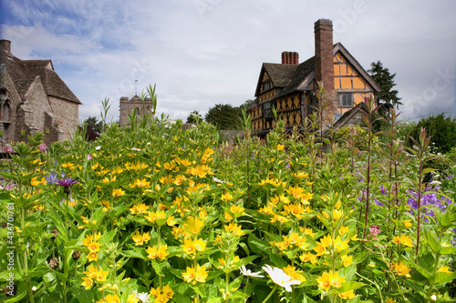 The inner courtyard, Great Hall, church and gatehouse of Stokesay Castle, Shropshire, UK, seen from across the glorious herbaceous borders