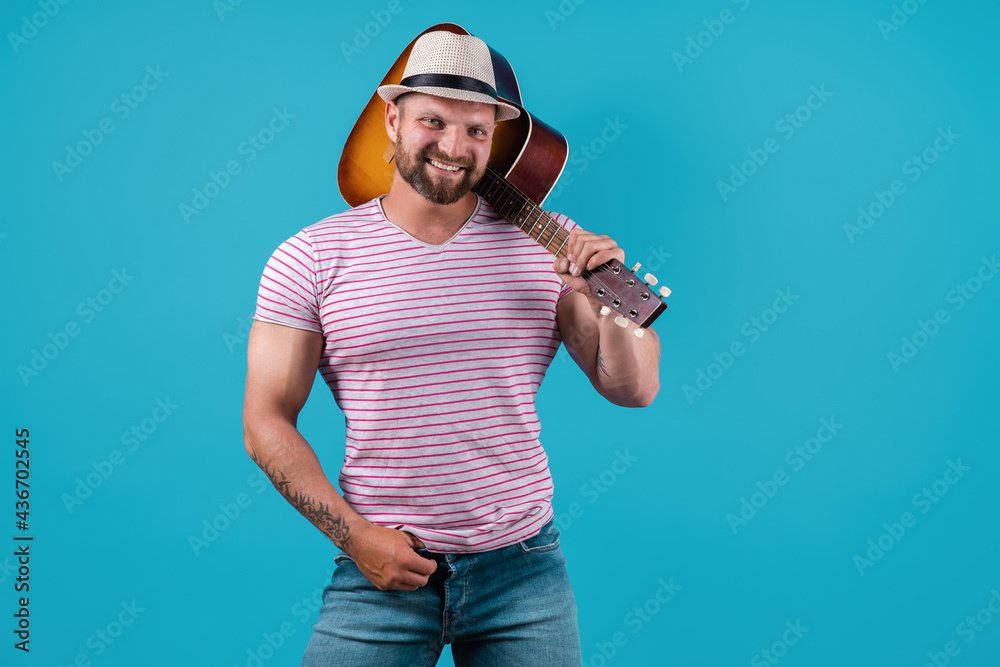 Fototapeta premium Handsome african american retro styled guitarist playing acoustic guitar isolated on blue background