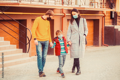 Air pollution concept. Prevention coronavirus. Parents and kid wearing a surgical mask.Coronavirus quarantine. Family going walk