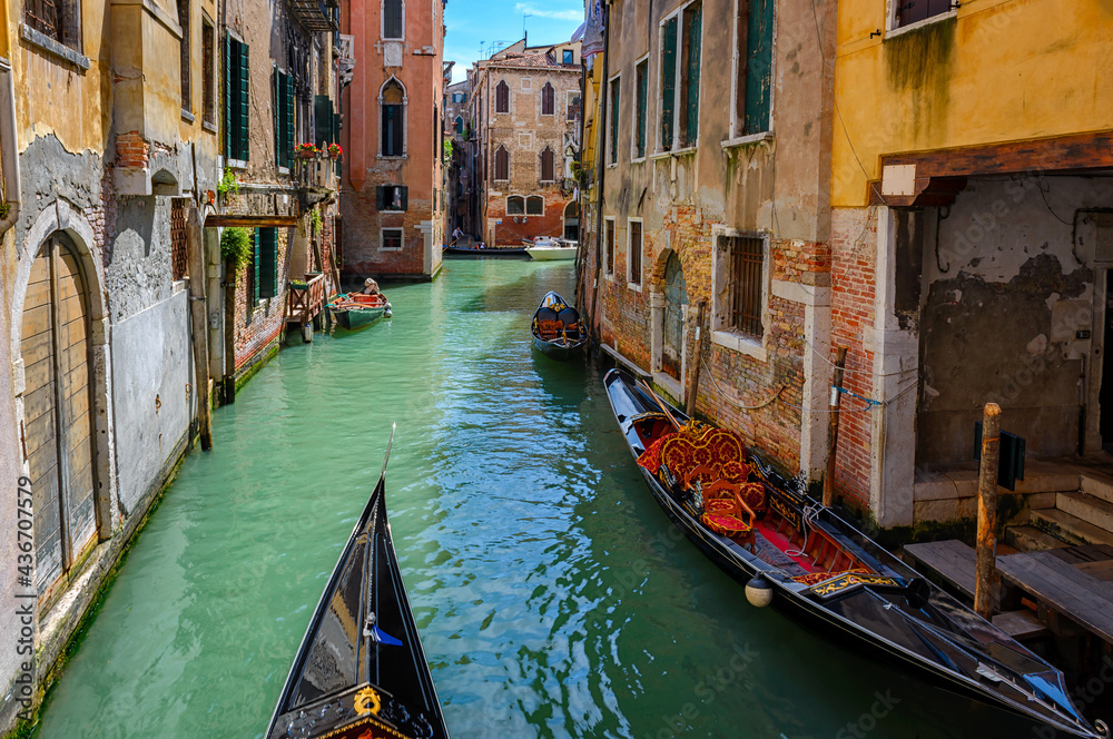 Narrow canal with gondola in Venice, Italy. Architecture and landmark of Venice. Cozy cityscape of Venice.