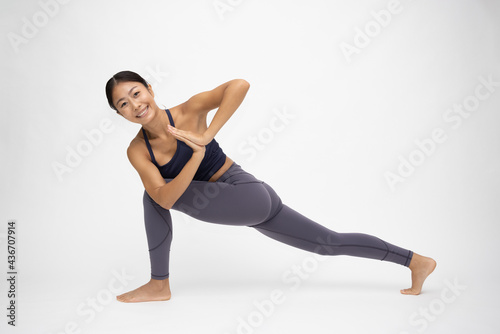 Young Asian woman doing yoga practices isolated on white background, Yoga pose concept © comzeal