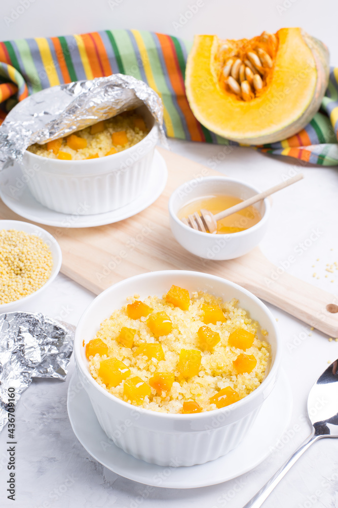 Millet porridge with pumpkin slices in light forms for baking on a light background. Vegetarian diet. Traditional autumn cuisine. Millet porridge with pumpkin slices in light forms for baking on a light background. Vegetarian diet. Traditional autumn cuisine.
