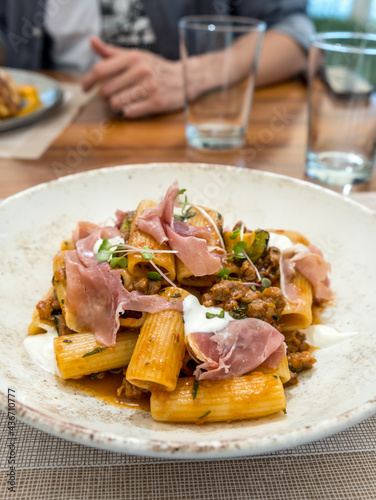 Fototapeta Naklejka Na Ścianę i Meble -  Pasta rigatoni with bolognese sauce, prosciutto and dollops of ricotta cheese