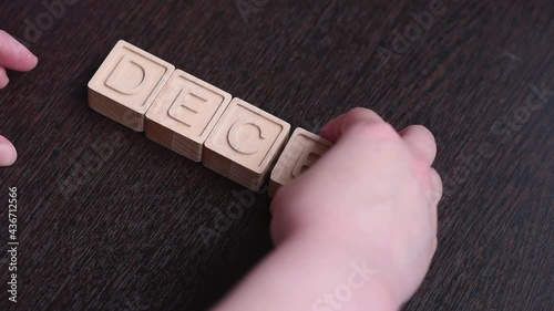 A female hand builds word deceit with wooden cubes. Concept photo