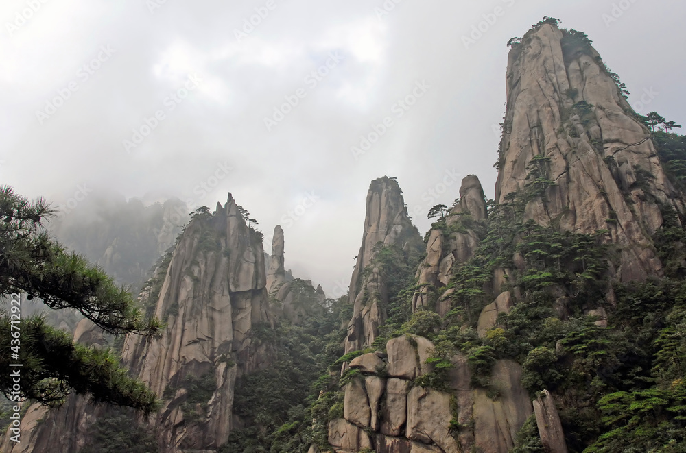 Sanqingshan Mountain in Jiangxi Province, China. Misty mountain scenery with rocky peaks on Mount Sanqing. Sanqingshan is a sacred Taoist mountain famous for its rocky outcrops and lush forests.