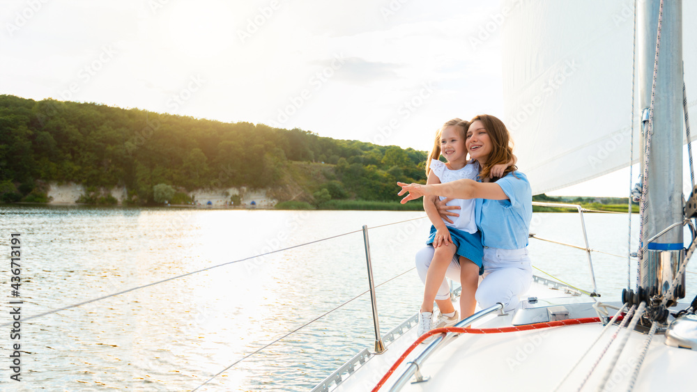 Naklejka premium Cheerful Mother And Daughter Enjoying Sailing During Yacht Ride Tour