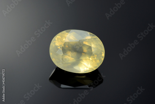 Natural, genuine oval faceted, transparent, light yellow color orthoclase feldspar gemstone setting for making jewelry. Mineral potassium aluminum silicate. Dark gradient background. Gemology theme. photo