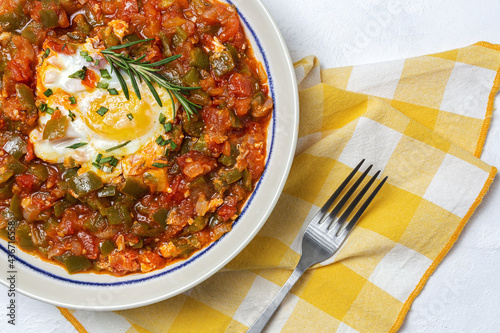 Vegetable dish pisto manchego made of tomatoes, zucchini, peppers, onions with fried egg photo