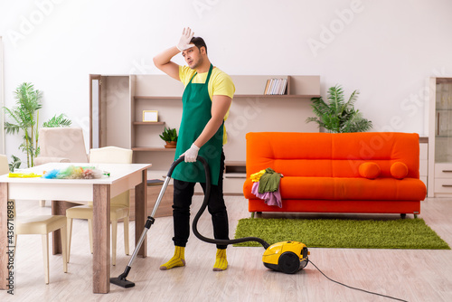 Young male contractor cleaning the house indoors