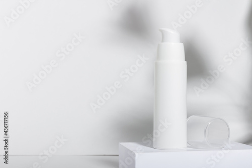 White cosmetic tube for cream, lotion, serum or face mask on the runway with leaf shadows. Professional cosmetics for skin care. Organic cosmetics. photo
