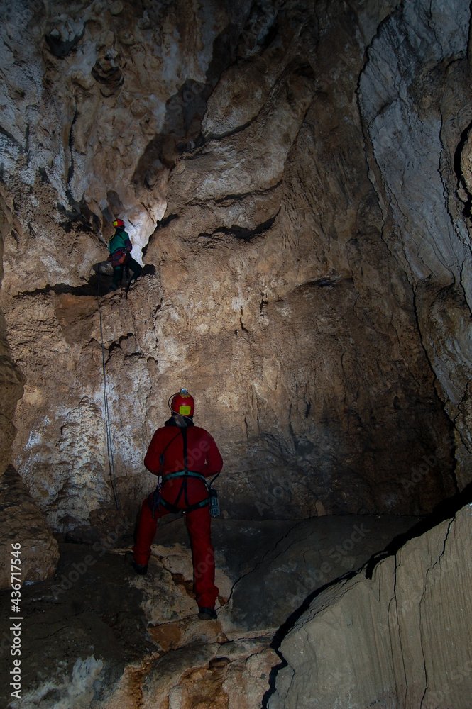 cave speleologists in the meanders of the earth. rock, stalactites and stalagmites cave speleologists in the meanders of the earth. rock, stalactites and stalagmites