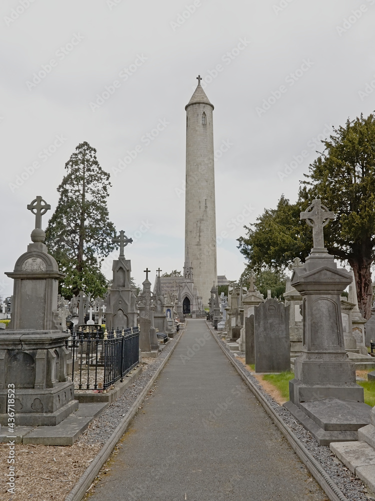 Round tower in between old grave tombs in Glasnevin cemetery, Dublin