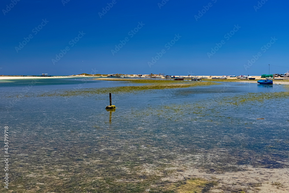 View of boats in the bay at low tide on the beach in the Mediterranean Sea on the island of Djerba, Tunisia
