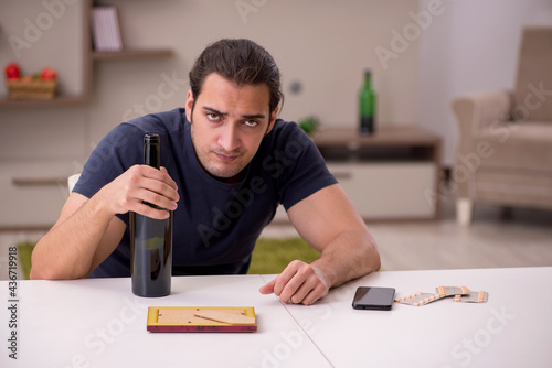 Young sick male alcoholic suffering at home