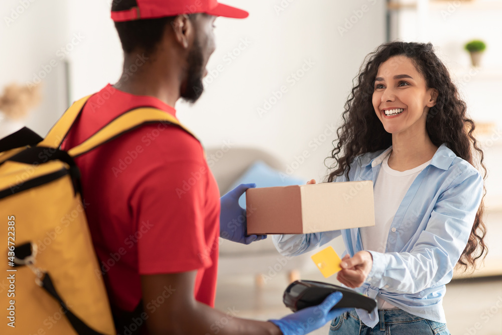 Portrait of black man holding POS machine for payment