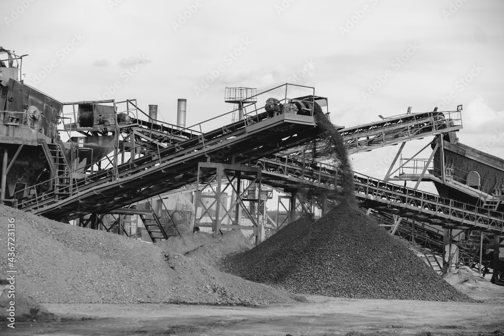 Industrial background - crusher (rock stone crushing machine) at open pit mining and processing plant for crushed stone, sand and gravel - obrazy, fototapety, plakaty 