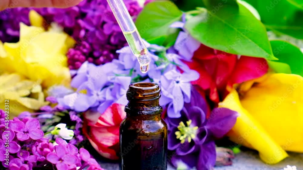 Essential oil and flower extract in a small bottle. Selective focus. Essential oil and flower extract in a small bottle. Selective focus.
