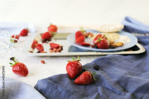Healthy breakfast ingredients on the table  strawberries  oatmeal and nuts on a light background
