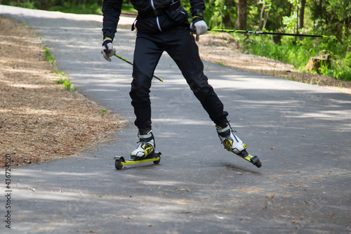 A man on a roller ski rides in the park.Cross country skilling. photo