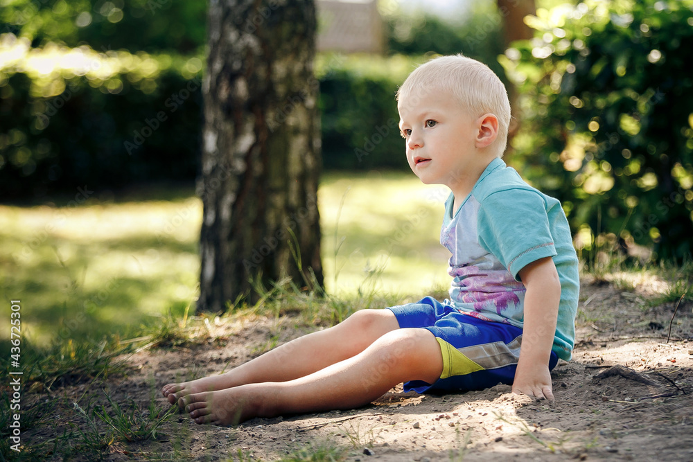 Barefoot boy sits on the sand