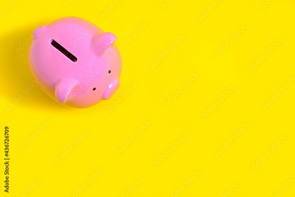 Naklejka premium Pink Piggy Bank on Yellow Background