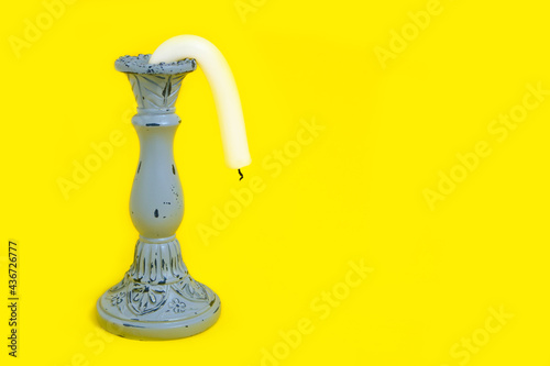 Candle Holder with a Drooping Candle on a Yellow Background Concept Impotence Impotence and Old Age in Sex photo