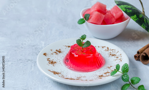 Jelly with mint and cinnamon on a white plate on a light background. Homemade watermelon dessert. Copy space.