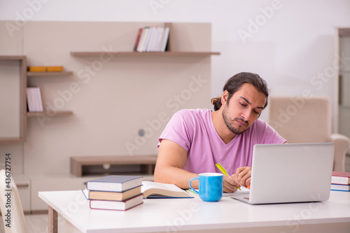 Young male student preparing for exams at home