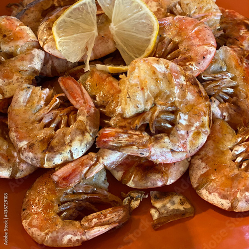 grilled king prawns with lemon on a plate