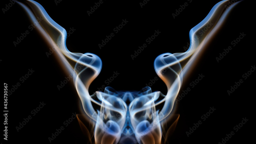 Swirls of Colorful smoke against a black background that resemble a Rorschach test or an alien, monster that spread its wings