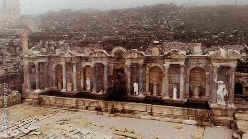 Partially reconstructed Nymphaeum building at ruins of ancient city of Sagalassos on foggy winter day, Turkey photo