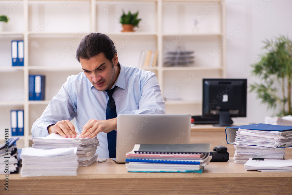 Fototapeta premium Young male employee and too much work in the office