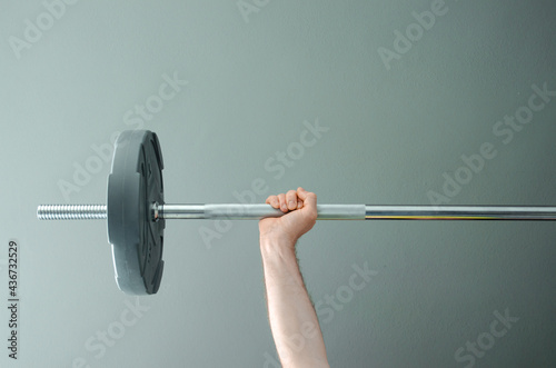 Photo of muscular mixed race man workout with barbell in home gym