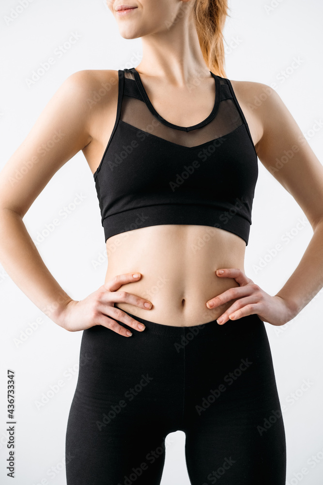 Woman activewear. Clothing template. Sports apparel fashion. Fitness  outfit. Front view of female athlete model with slim body in logo mockup  black crop top leggings isolated on light. Stock Photo