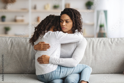 Φωτογραφία Depressed black mother hugging her daughter, closeup