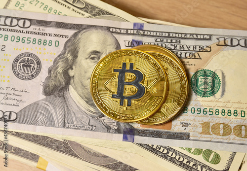 Bitcoin coins on a bundle with dollars. The concept of investing money in cryptocurrency and making a profit due to the fall in the dollar exchange rate. Banning the use of bitcoin photo