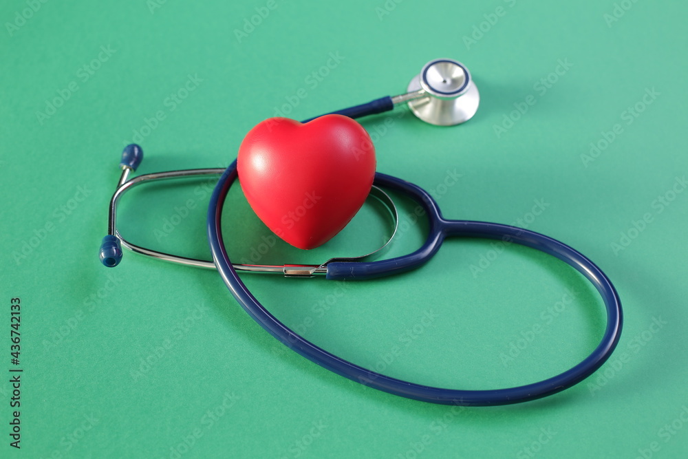 Medical stethoscope and heart on green background Medical stethoscope and heart on green background