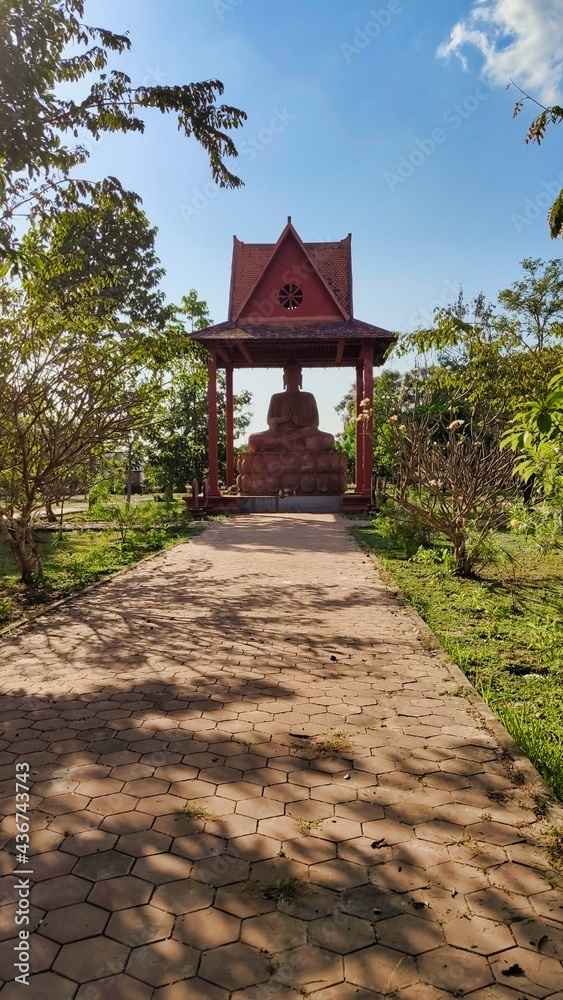 Fototapeta premium Way to Buddha statue in the gazebo in the park. Cambodia. South-East Asia