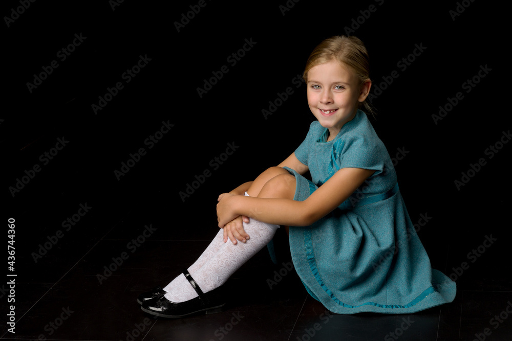 Cute girl sitting on floor hugging her knees Stock Photo | Adobe Stock