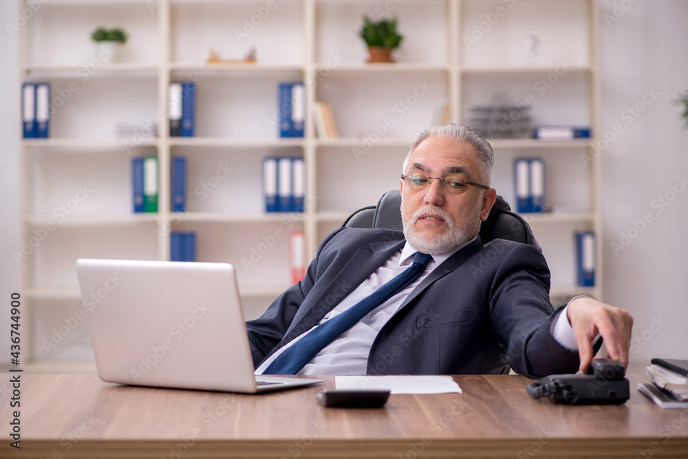 Old male employee working in the office Old male employee working in the office
