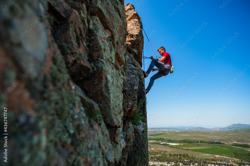Fototapeta premium Climber with climbing equipment hanging on a rope