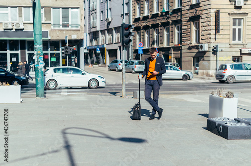 Young businessman walking with travel bag in the city . © qunica.com