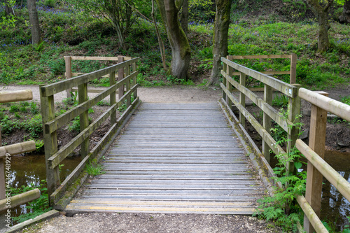 Wooden foot bridge with anti slip strips across a small stream