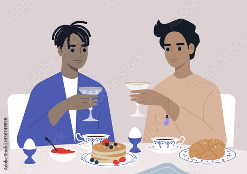 Fancy breakfast with champagne in a fine dining restaurant, a gay couple drinking sparkling wine and eating pancakes and croissants