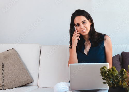 Young woman working from home using laptop and internet